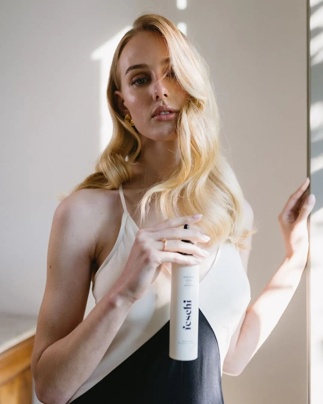 Blonde Frau hält das intense care - 10 second treatment von feschi in der Hand