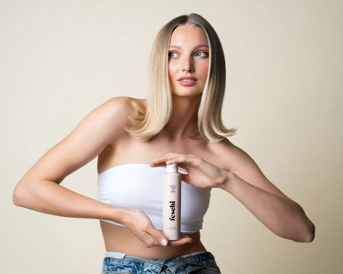 Frau mit blonden Haaren hält feschi Silbershampoo in der Hand