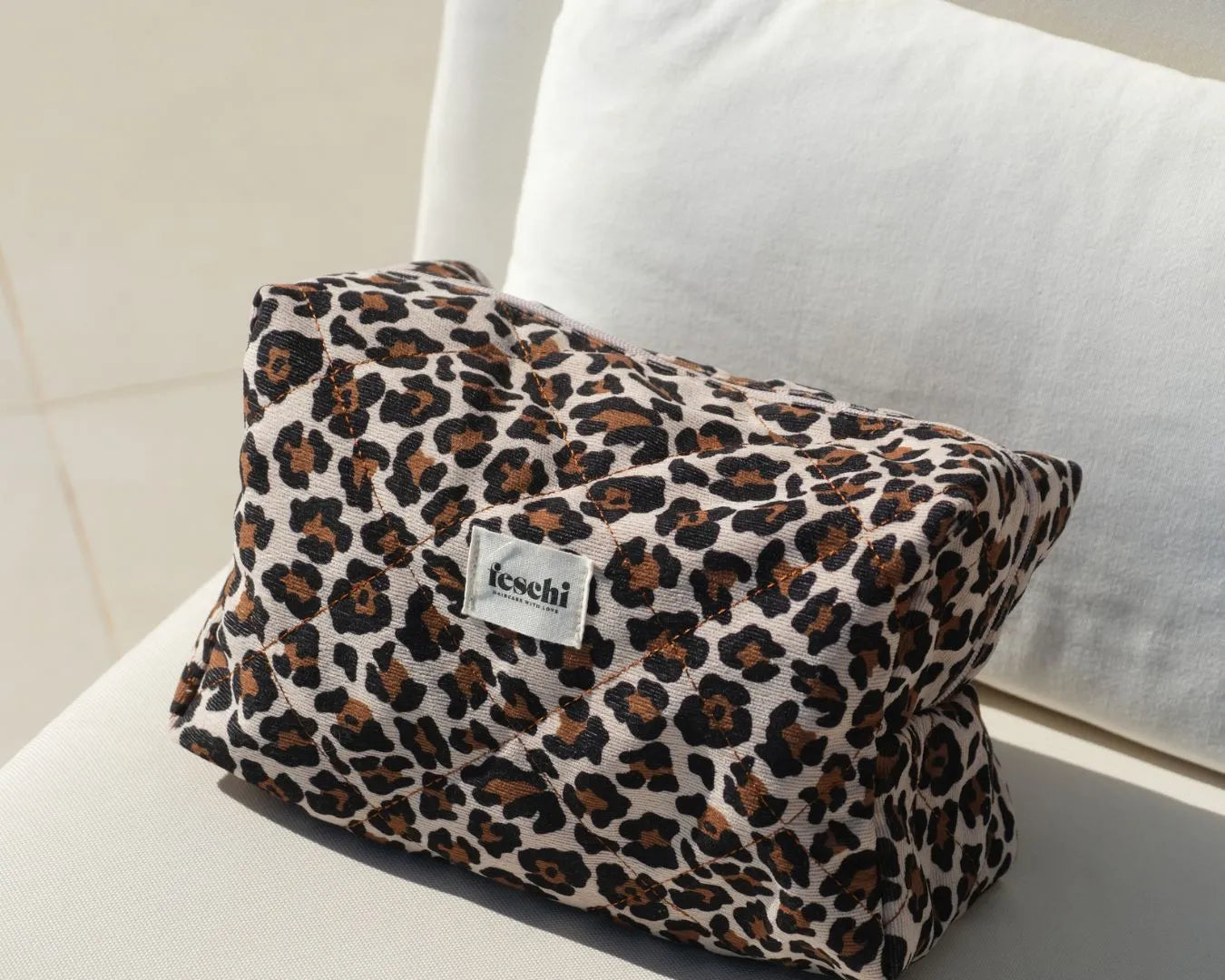 feschi Leopard Beauty Bag steht auf weißem Sofa