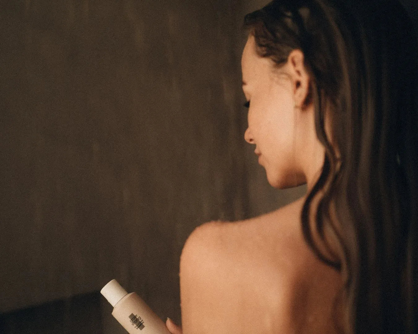 Frau steht in Dusche und hält das grow strong Shampoo von feschi links neben ihrem Körper