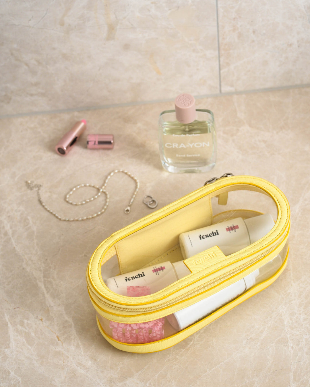 Gelbe Kosmetiktasche mit feschi Produkten und anderen Schminkartikeln im Badezimmer