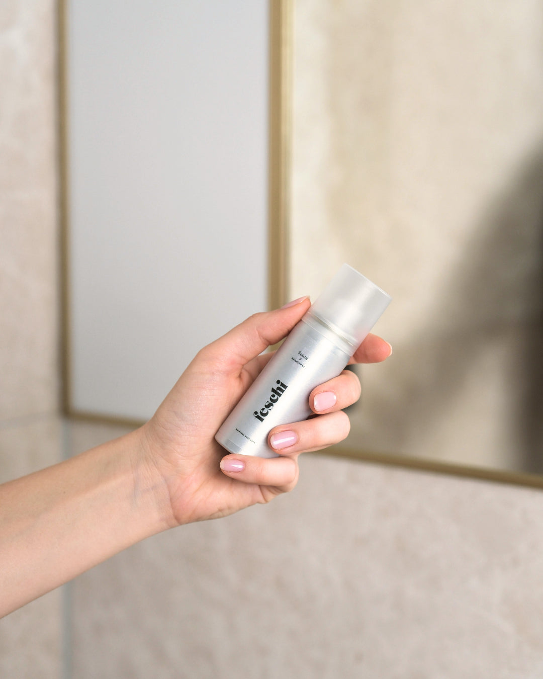 Haarspray von feschi in Reisegröße wird in Hand gehalten