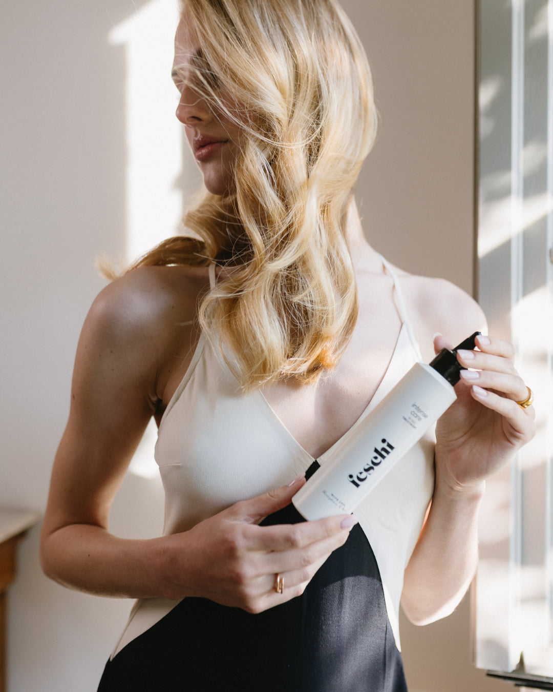 Blonde Frau mit glänzendem Haar präsentiert das feschi intense care - 10 sec. Treatment.