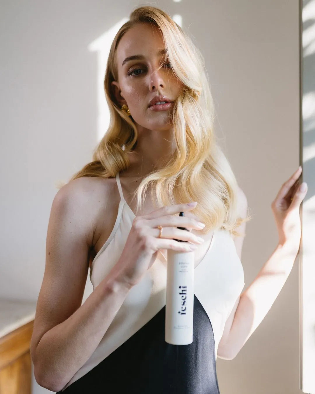 Frau mit blonden Haaren hält das intense care - 10 second treatment von feschi in der Hand