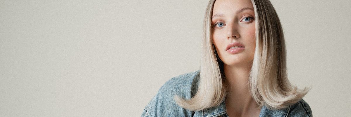 Eine blonde Frau mit glatten Haaren blickt in die Kamera