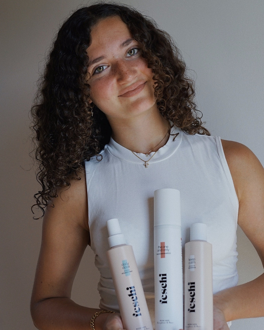 junge Erwachsene mit lockigem Haar präsentiert das feschi Teenie Set für schnellfettendes Haar.