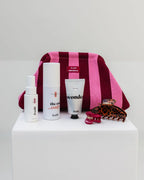 feschi x constantly_k Clutch in Pink und Bordeaux mit Haircare Produkten und Haarspangen