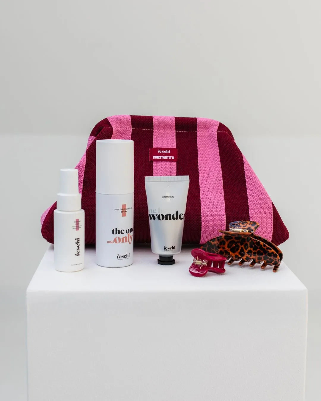 feschi x constantly_k Clutch in Pink und Bordeaux mit Haircare Produkten und Haarspangen