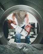 Foto von Innenseite aus Waschmaschine, wo das Aqua Dry Trockenshampoo von feschi gehalten wird