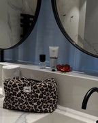 feschi Leopard Beauty Bag steht in Badezimmer auf Armatur