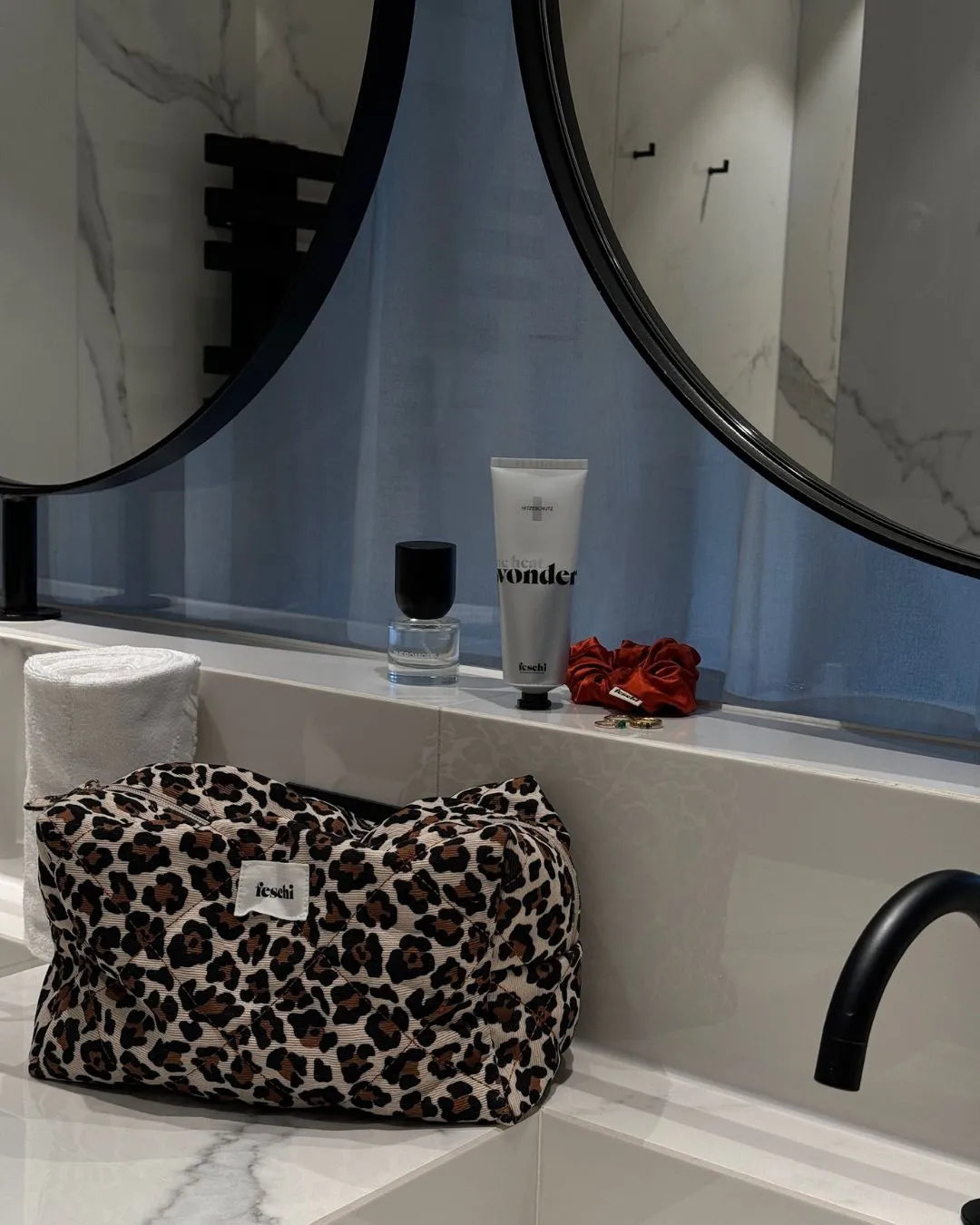 feschi Leopard Beauty Bag steht in Badezimmer auf Armatur