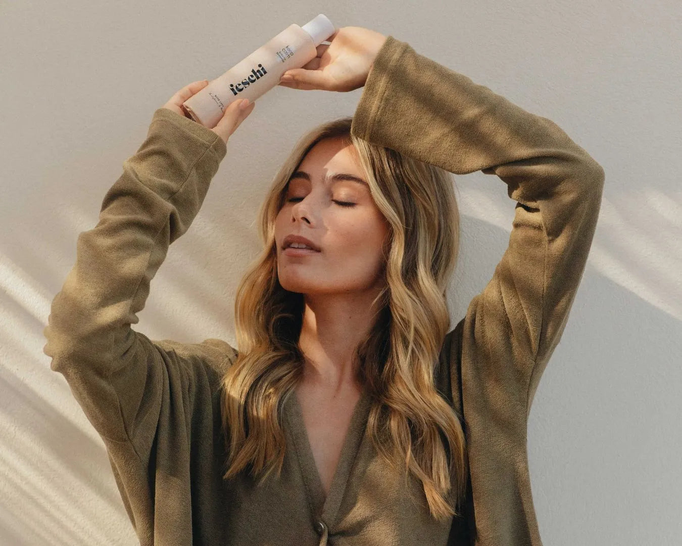 Frau mit langen blonden haaren hält keep calm shampoo von feschi über ihrem kopf