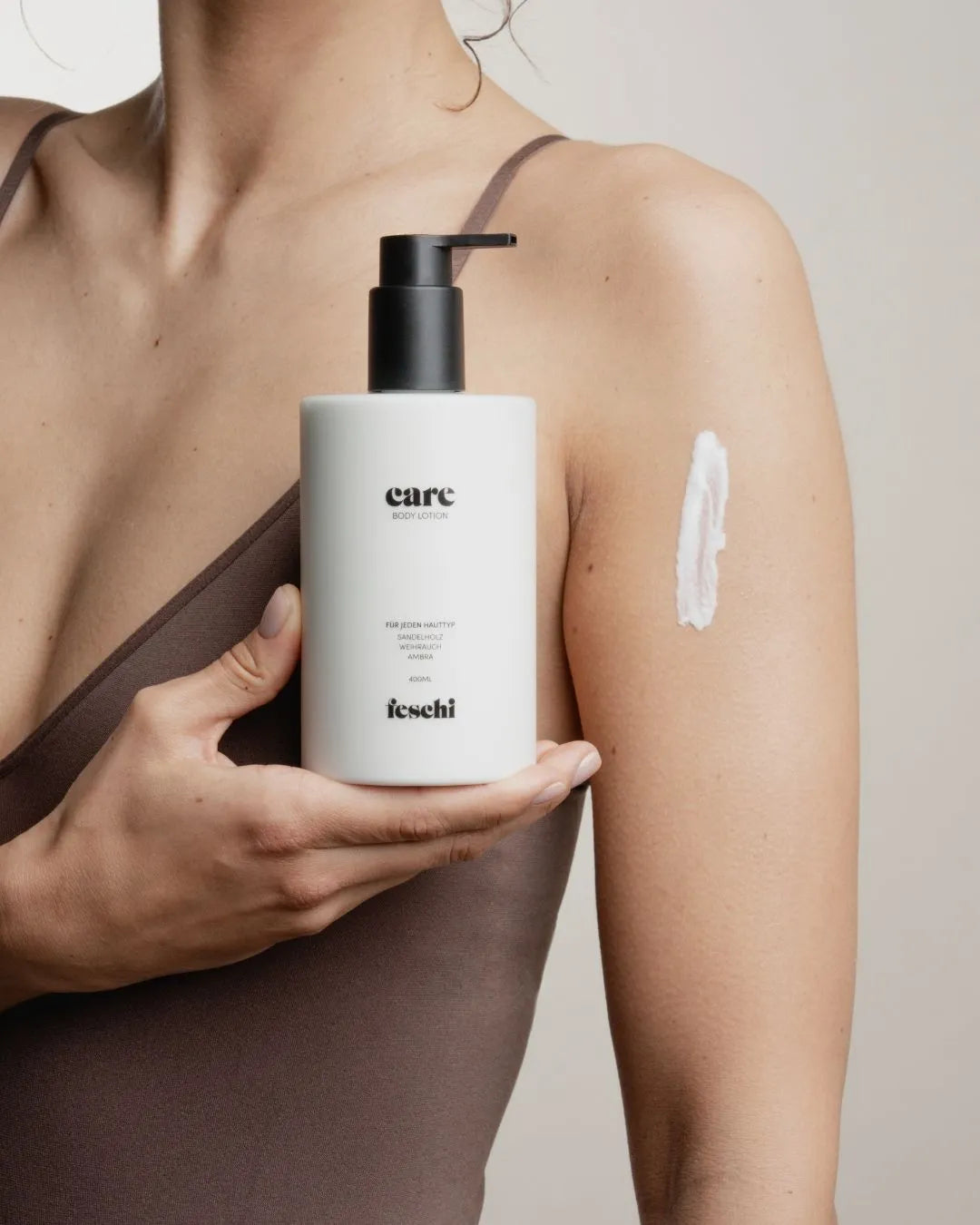 Körper einer Frau ist zu sehen und sie hält dabei eine Body Lotion von feschi in der Hand