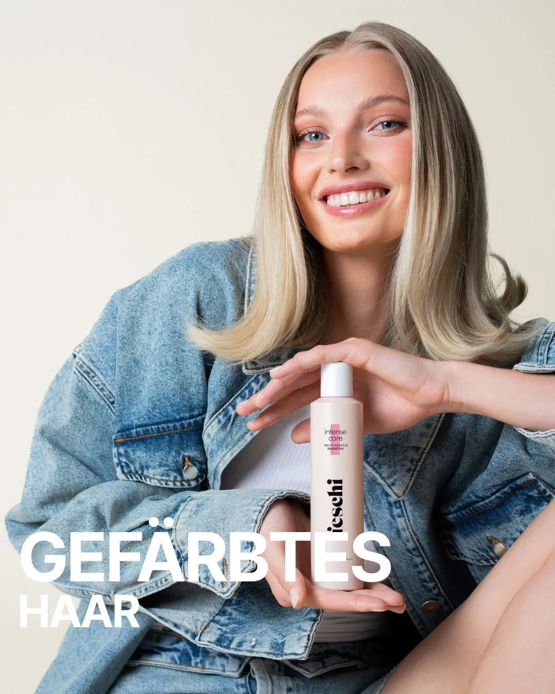 blonde Frau mit Jeansjacke lächelt in die Kamera und hält feschi intense care Shampoo in ihren Händen