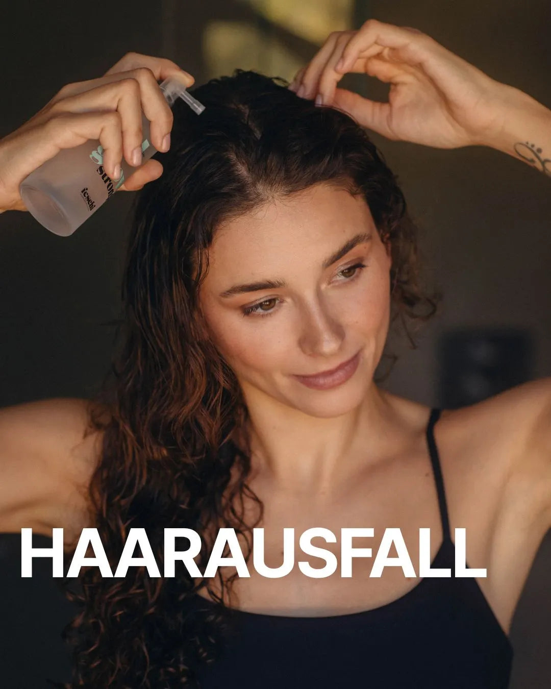 Frau mit braunem, lockigem Haar sprüht feschi grow strong Tonic an ihren Ansatz