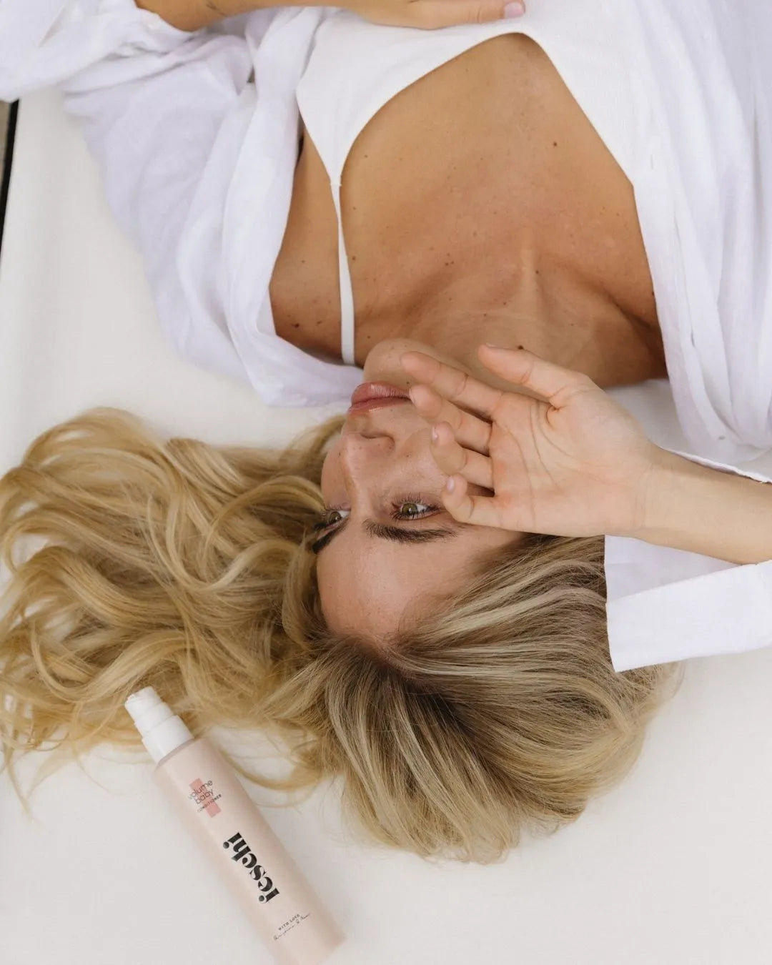 Frau liegt am Boden und neben ihr liegt der feschi Volumen Conditioner