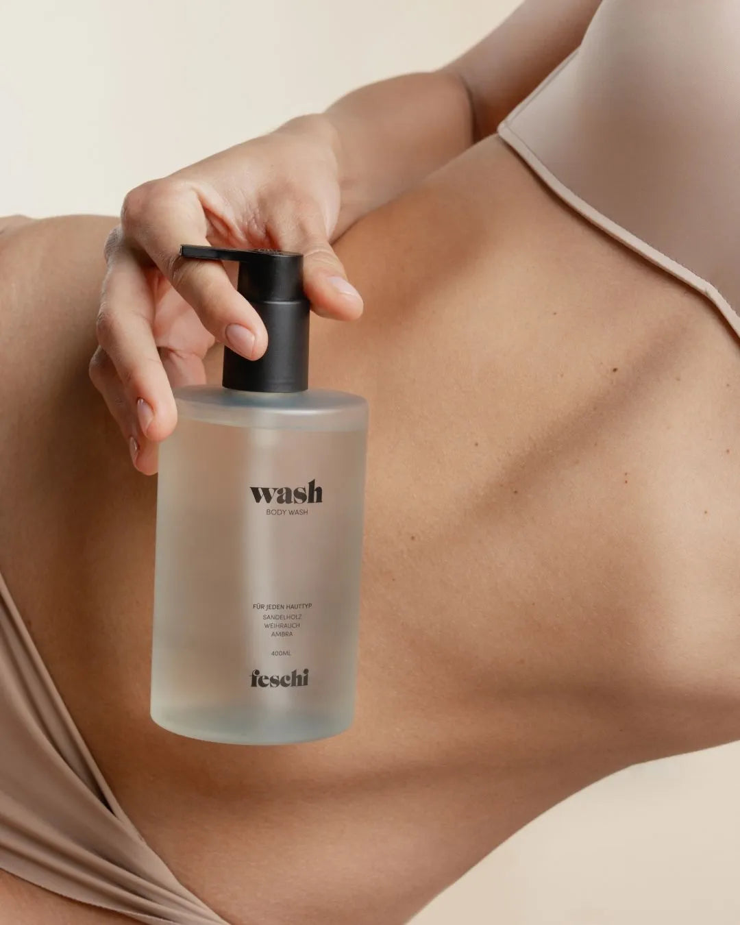 Frau in Unterwäsche hält die Body Wash von feschi in der Hand