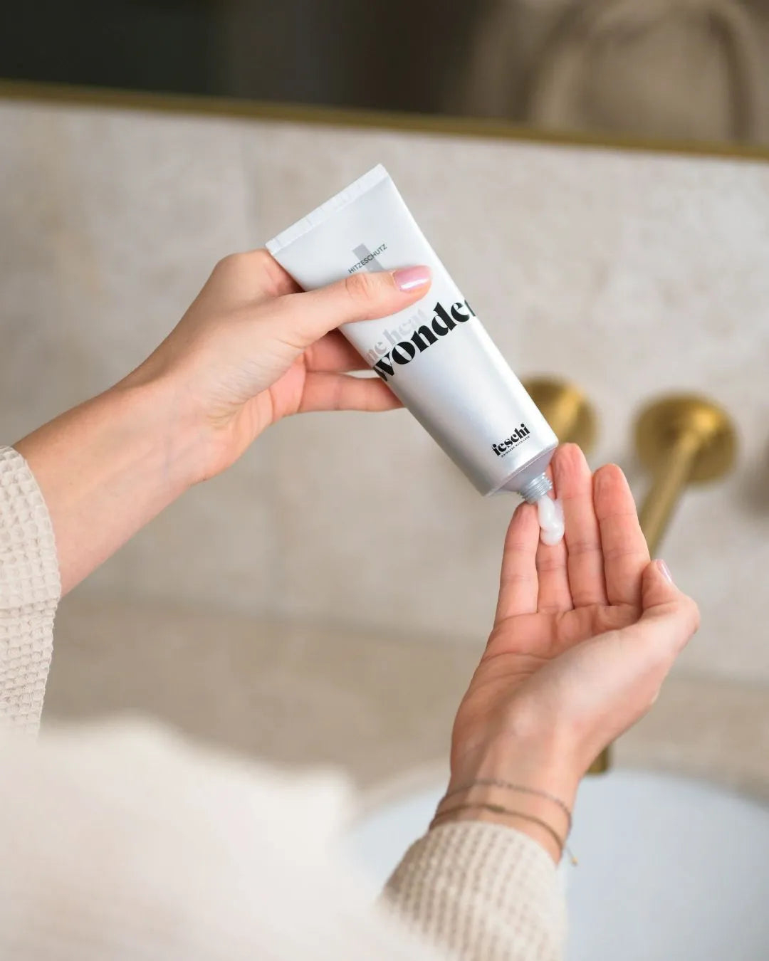 Zwei Hände, eine hält den feschi One Heat Wonder Hitzeschutz und drückt das Produkt in die andere Hand