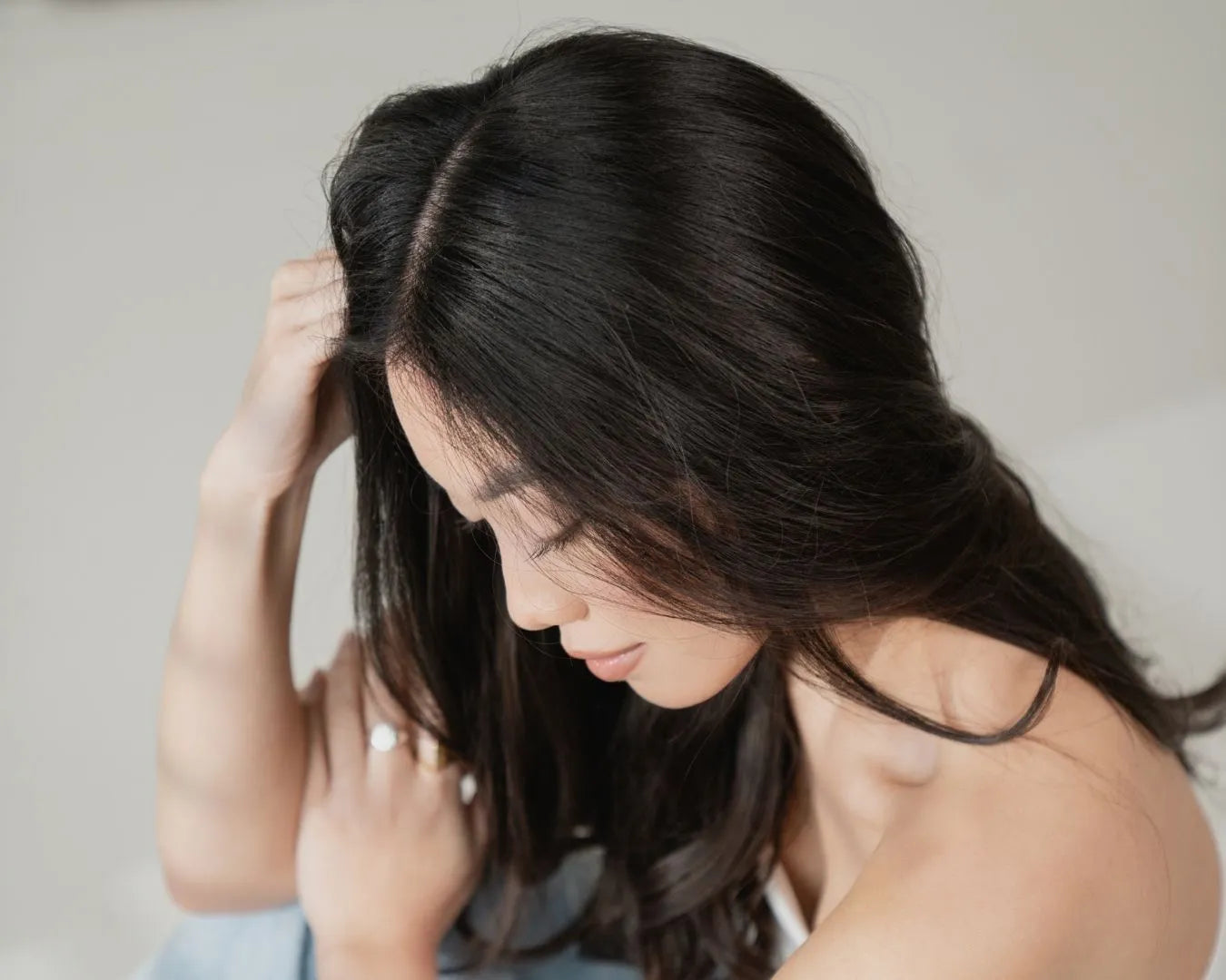 Frau mit dunkelbraunen Haaren, seitlich sitzend