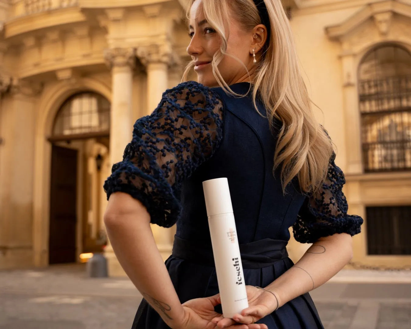 Frau von hinten hält in den verschränkten Armen im Rücken den feschi Smooth & Shine Anti-Frizz Spray