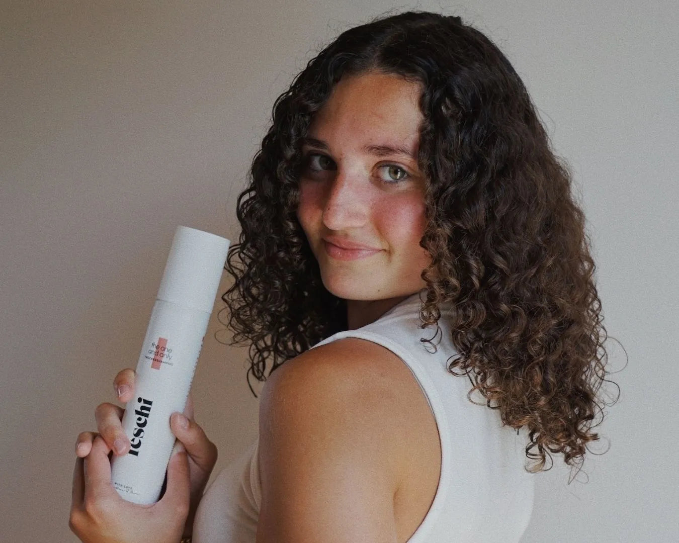 Teenager hält das Trockenshampoo von feschi in der Hand