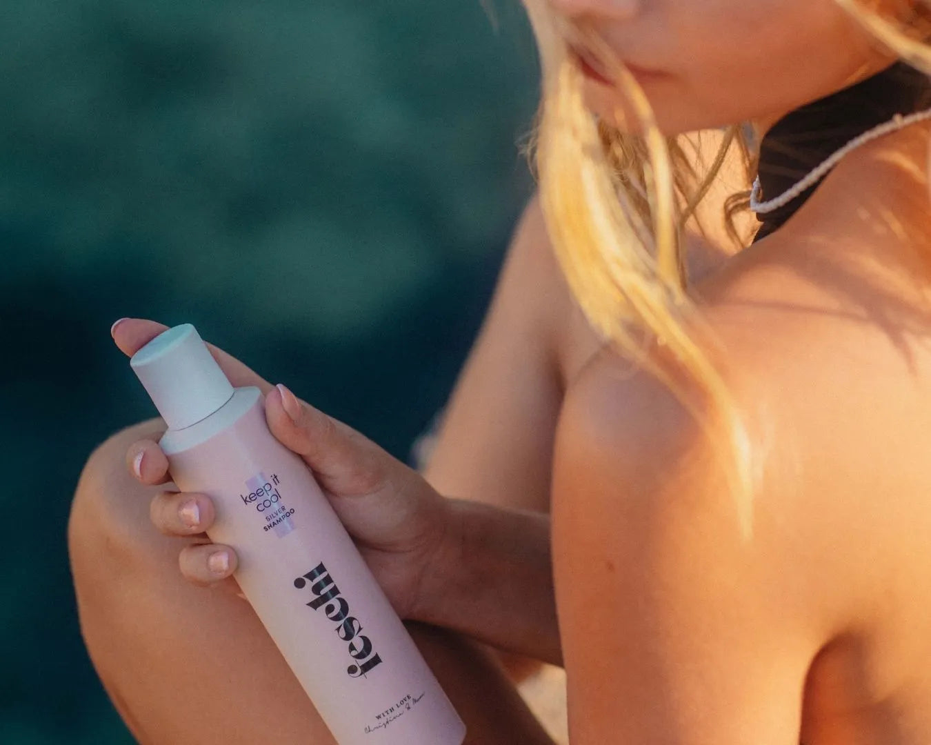 Silber Shampoo von feschi wird von Frau mit blonden Haaren gehalten