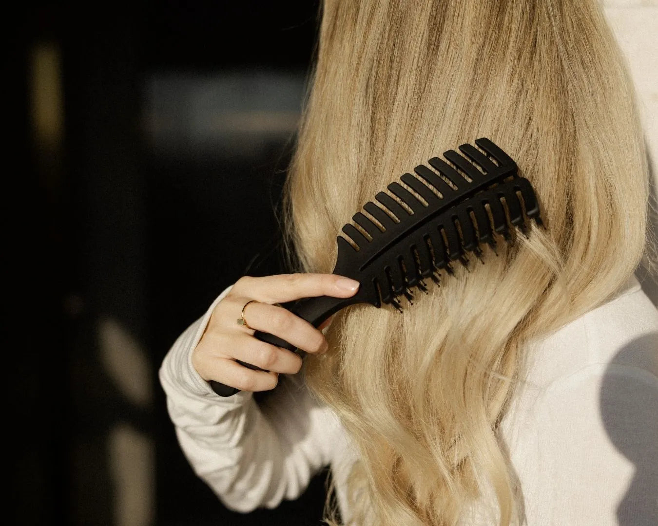 Frau von der Seite beim Haare bürsten mit der feschi Hair Brush