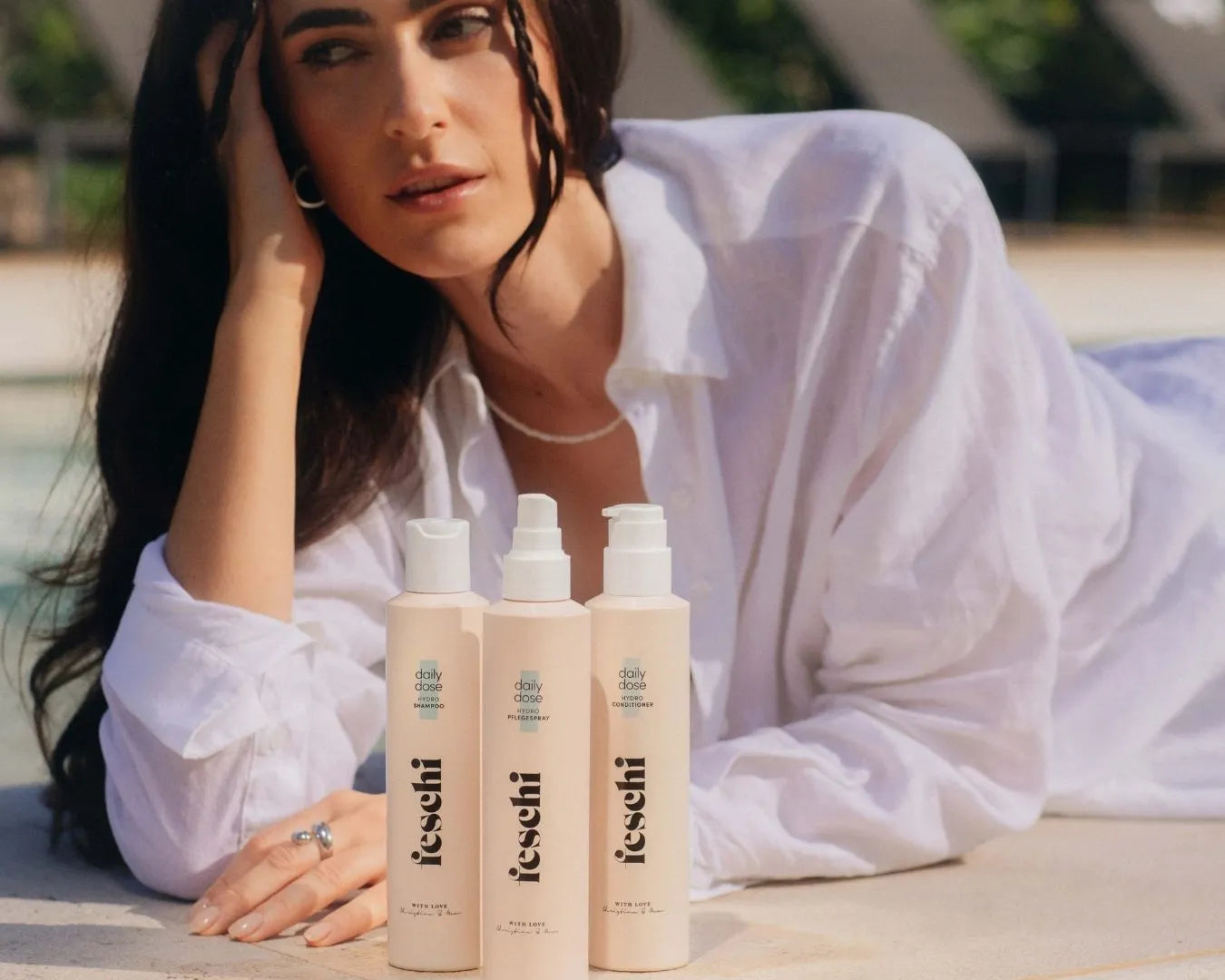 Frau mit dunklen, langen Haaren liegt am Boden und vor ihr steht die daily dose - Hydro Serie von feschi