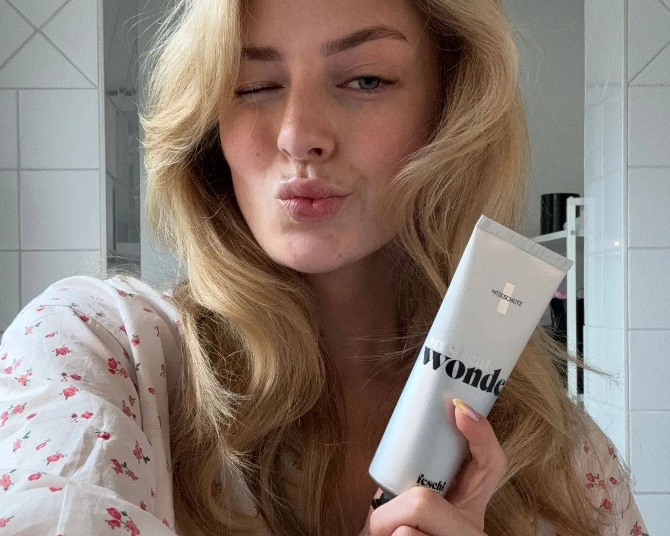 Selfie von einer Frau mit Blow-Out und dem Hitzeschutz von feschi in der Hand