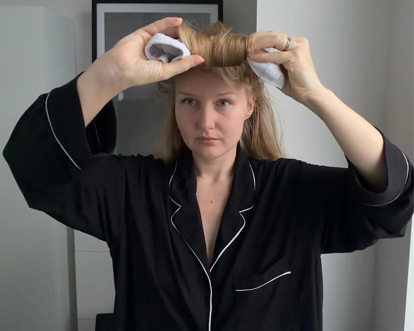 Frau, die sich gerade Locken mit Socken macht