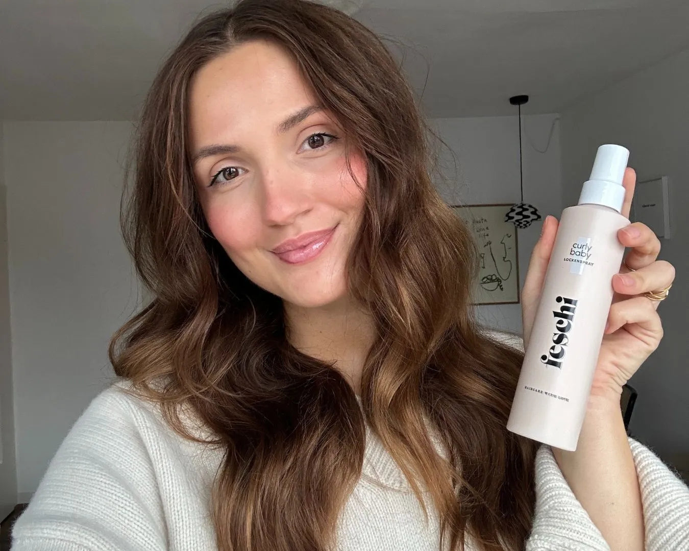 Frau die Lockenspray von feschi in der Hand hält