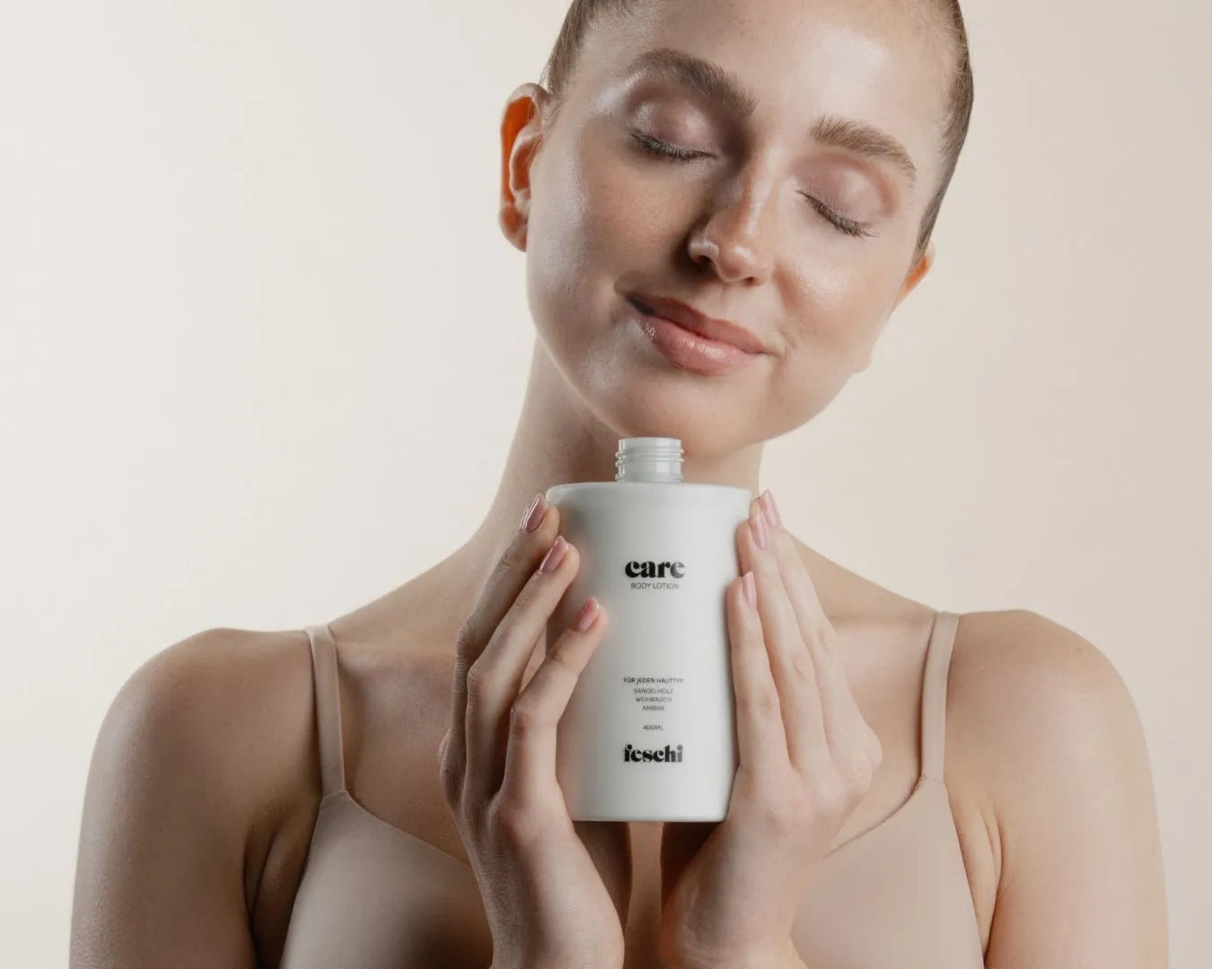 Frau riecht an feschi Body Lotion und hat Augen geschlossen