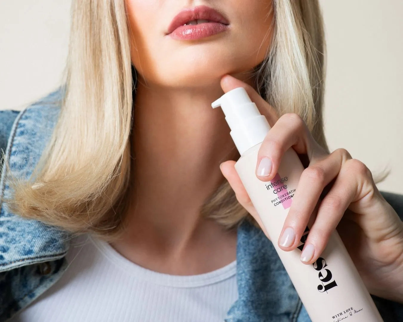 Ein Ausschnitt von einer blonden Frau, die einen Conditioner von feschi in der Hand hält