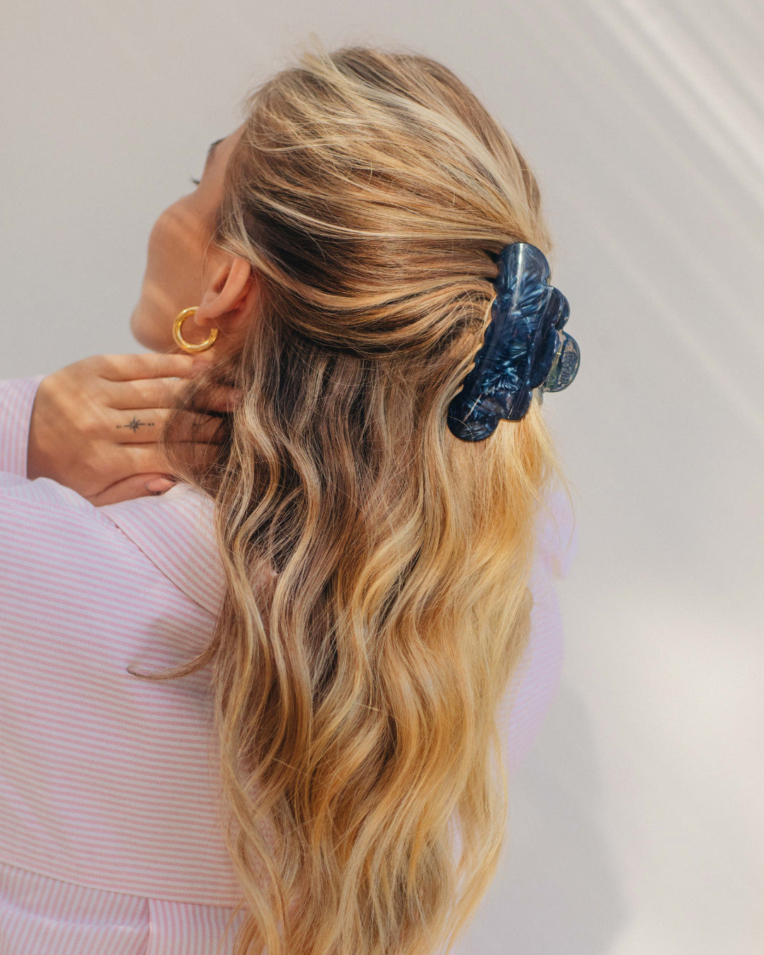 Frau mit langen, lockigen blonden Haaren und blauer Haarspange