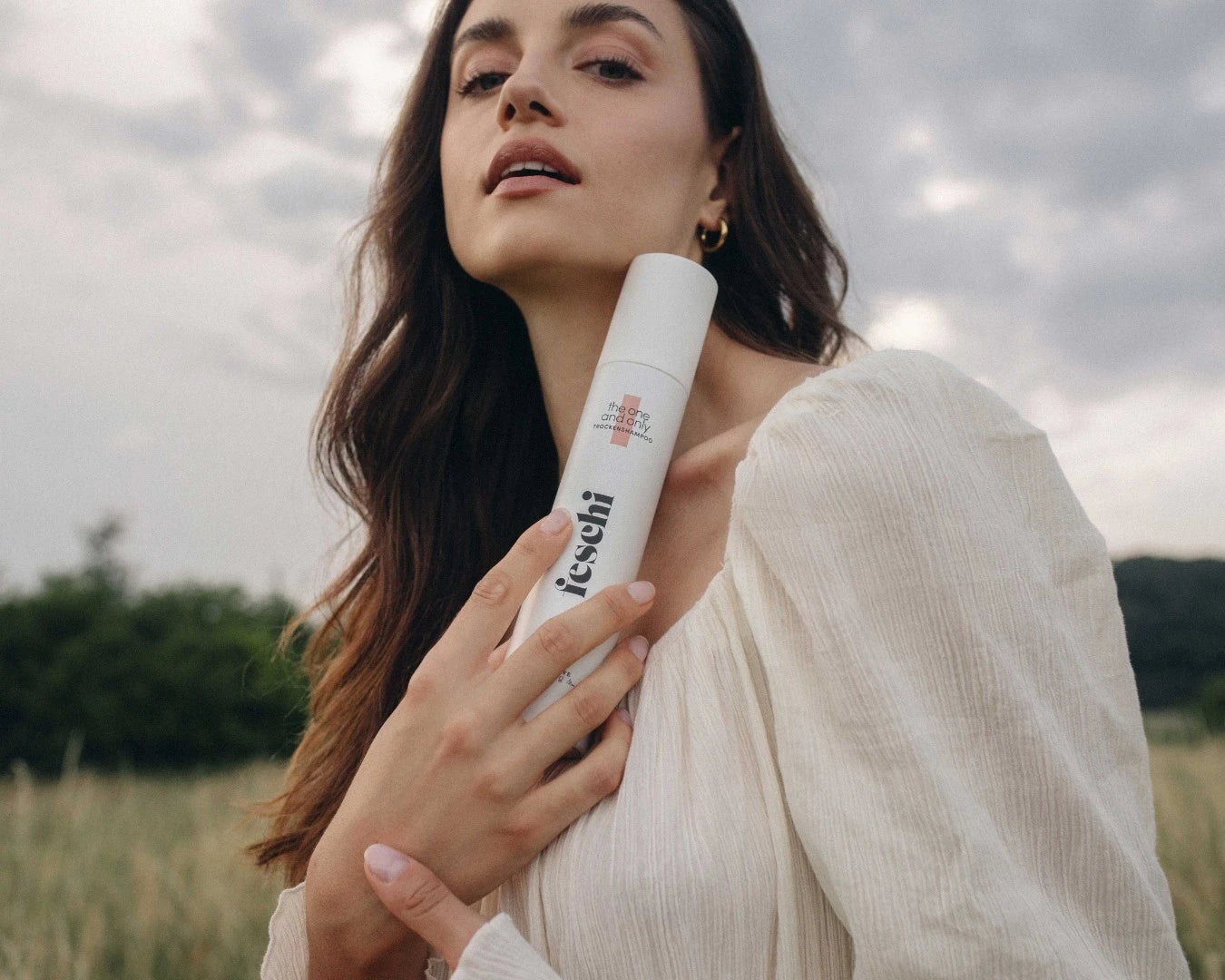 Frau hält das feschi Trockenshampoo Spray in der Hand