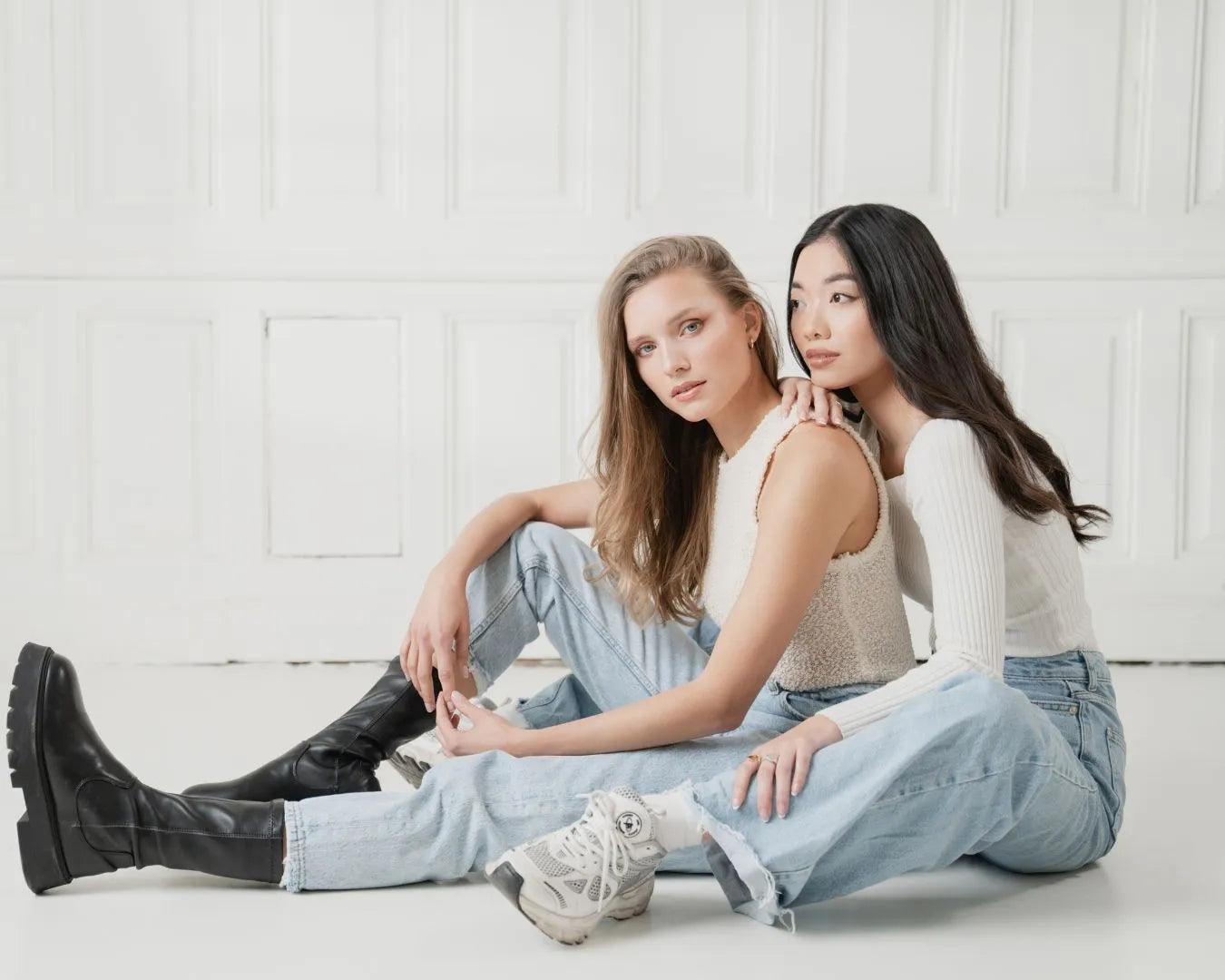 Zwei Frauen mit schönen langen haaren sitzen nebeneinander am boden