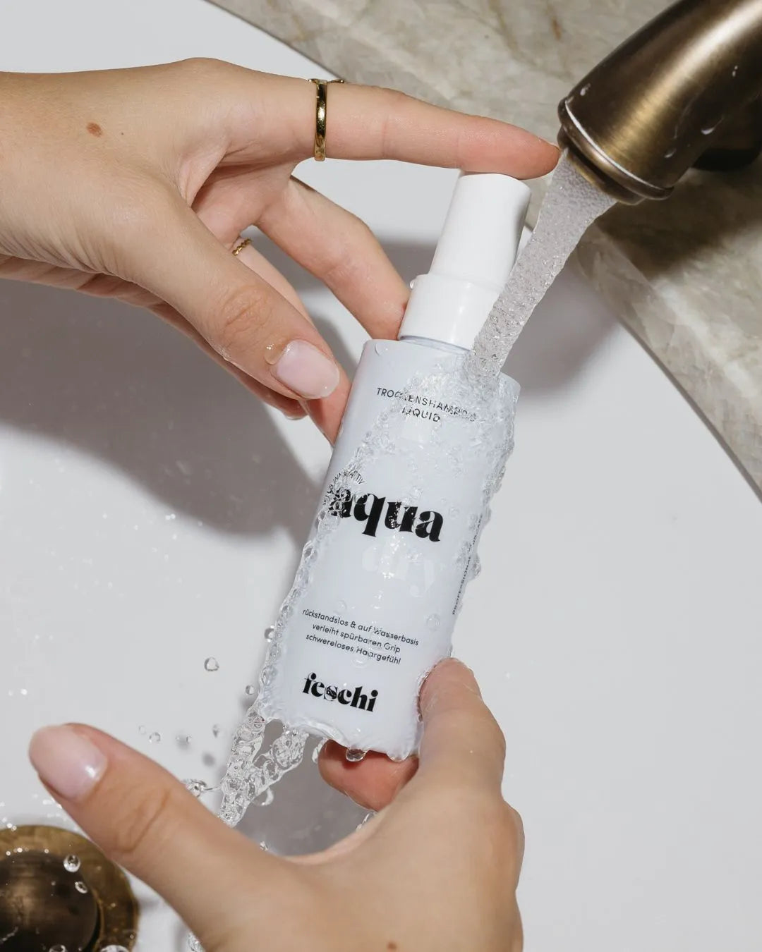 feschi Aqua Dry Trockenshampoo Liquid unter fließendem Wasser