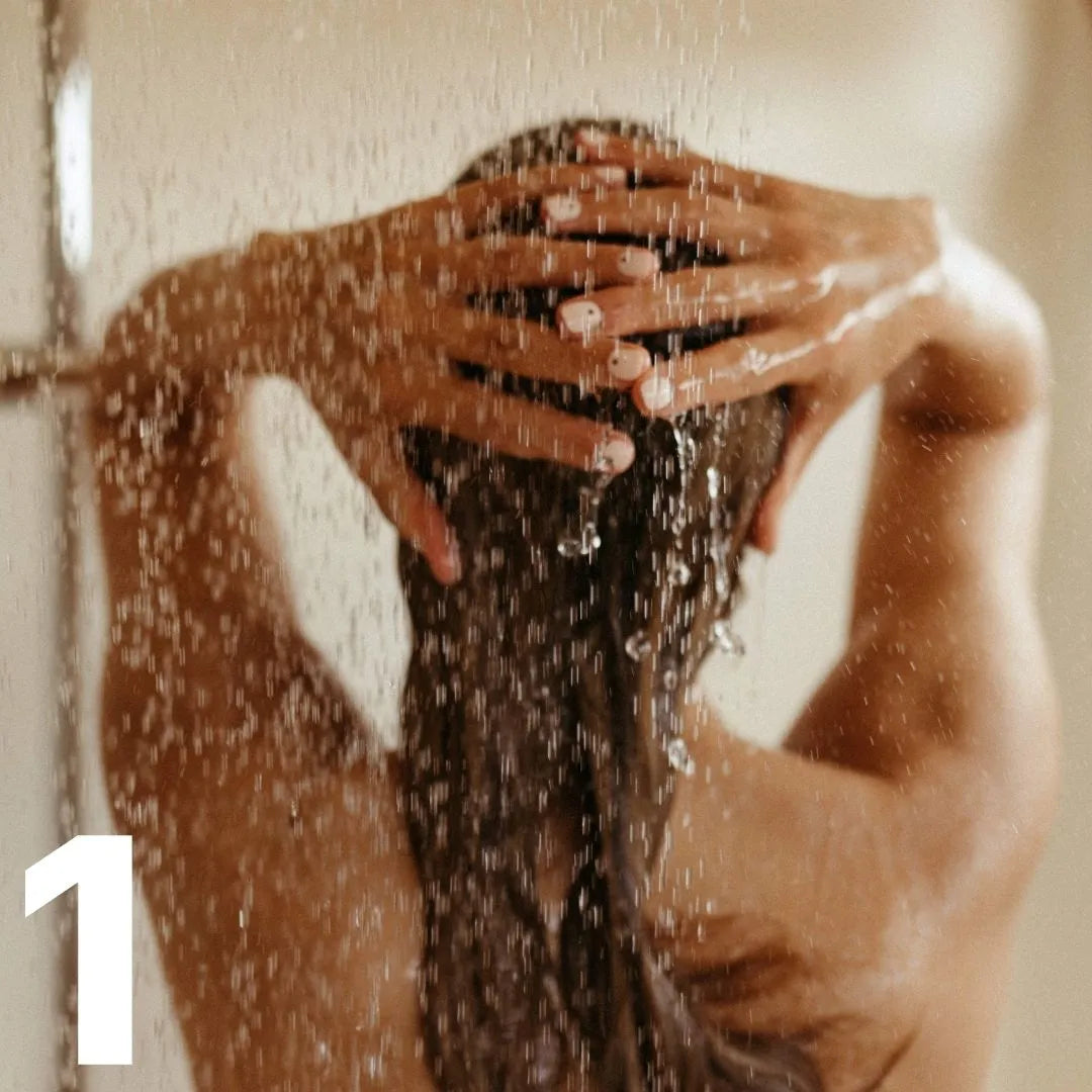 Frau von hinten unter der Dusche, wäscht ihre Haare