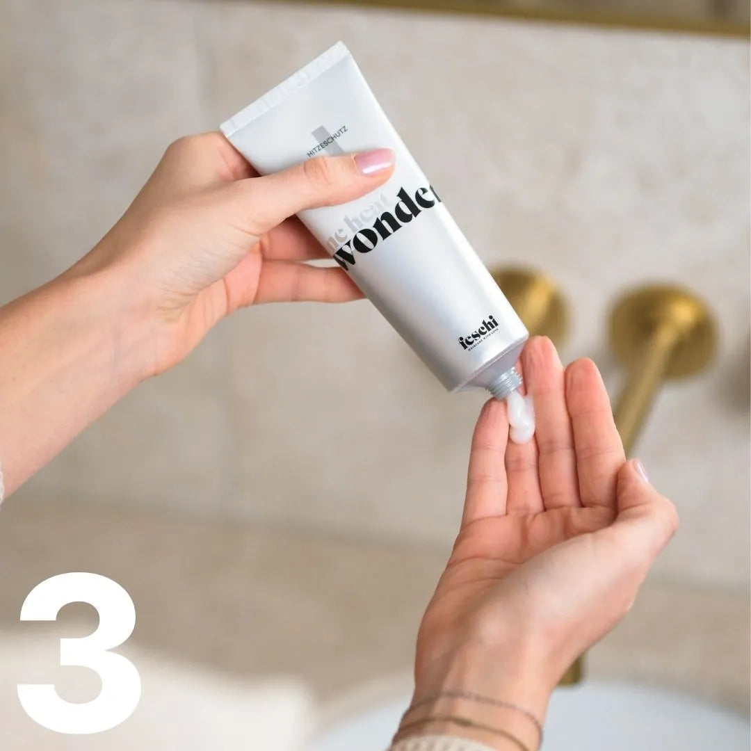 Zwei Hände, eine drückt Produkt aus dem feschi One Heat Wonder Hitzeschutz in die andere Hand