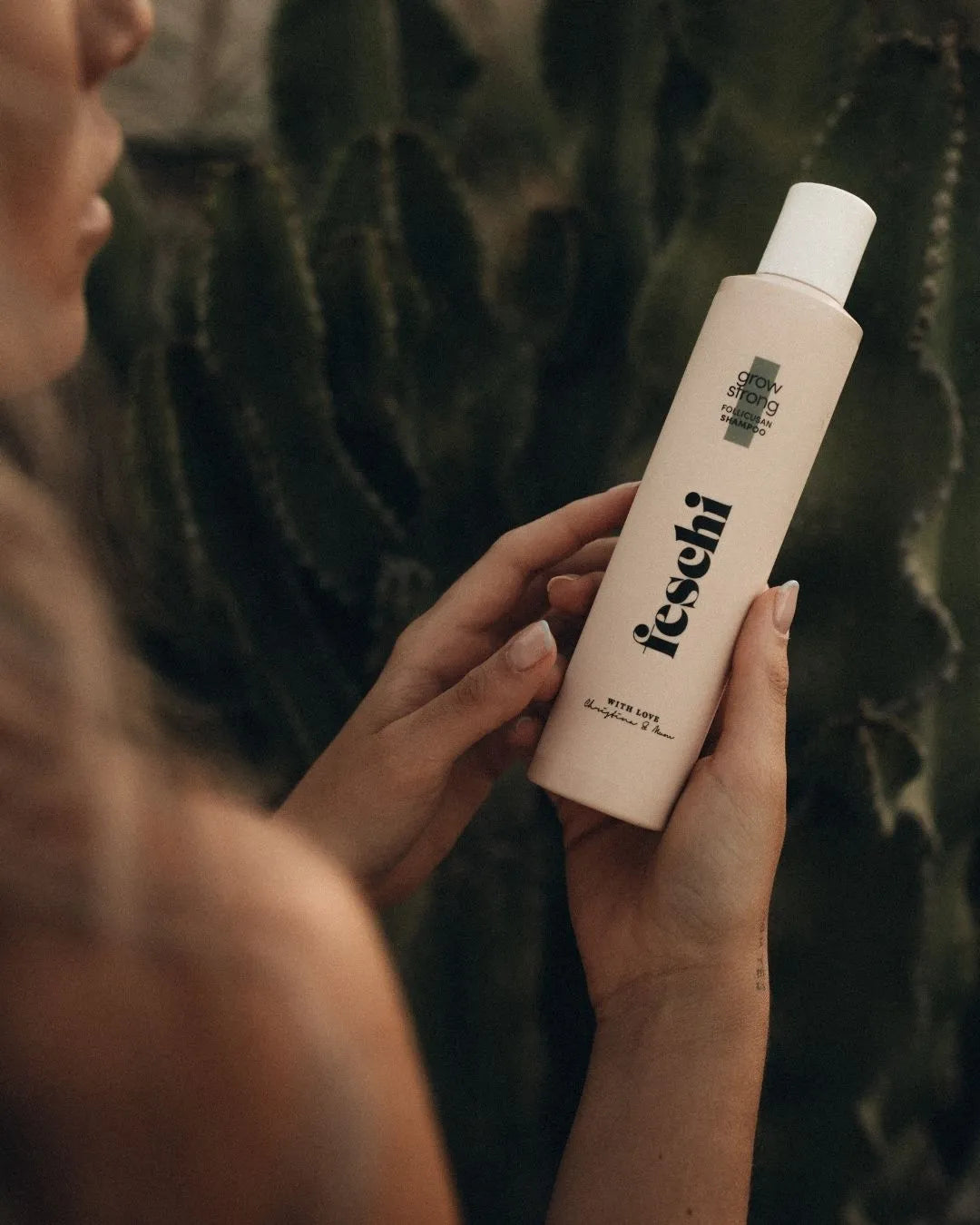 Nahaufnahme von feschi Grow Strong Shampoo in der Hand – hochwertige Haarpflege