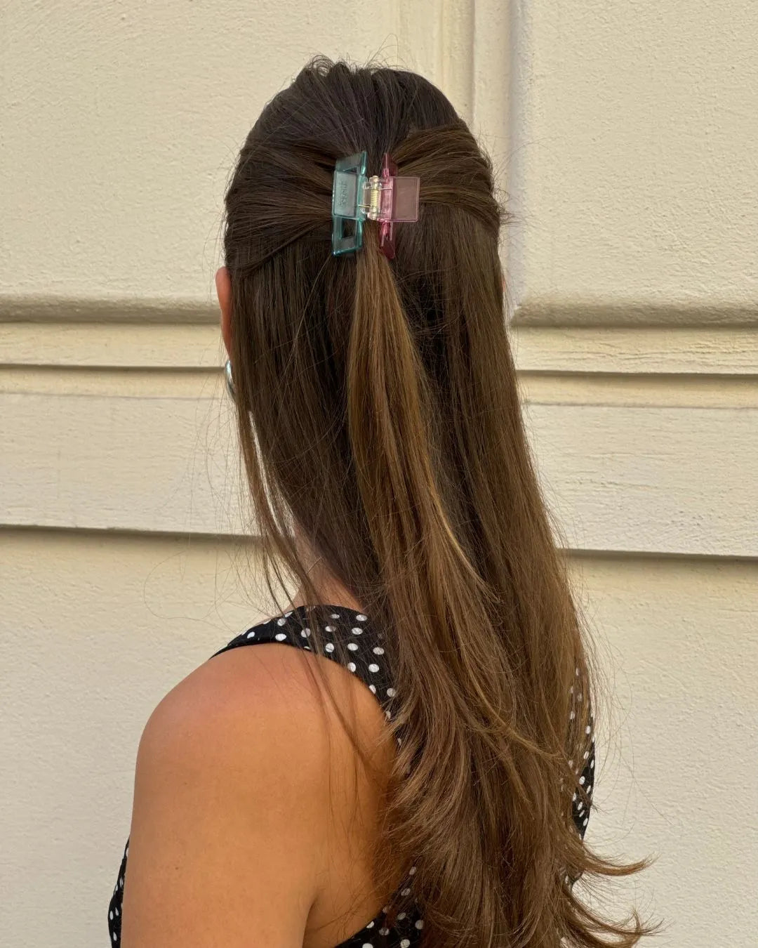 Frau vor Steinwand mit zweifärbiger feschi Haarspange in den Haaren