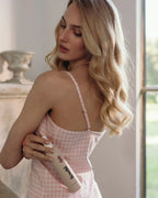 Model mit lockeren Wellen zeigt feschi Intense Care Spray - Leave-in Pflege für seidiges Haargefühl