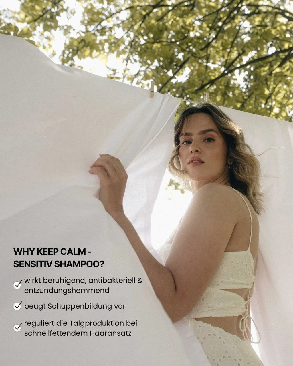 Frau in weißem Kleid hält feschi keep calm Sensitiv Shampoo mit Infos zu Wirkung gegen fettigen Ansatz & Schuppen