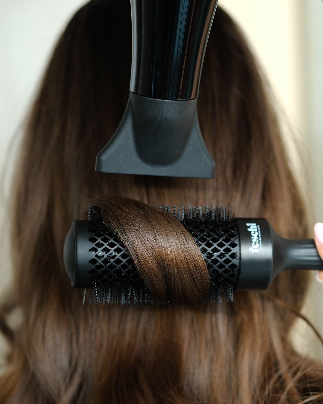 Person mit dunkelbraunen Haaren, die gerade ein Blow Out bekommt