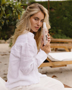 Frau mit fülligen Haaren hält Volumen Conditioner von feschi in der Hand