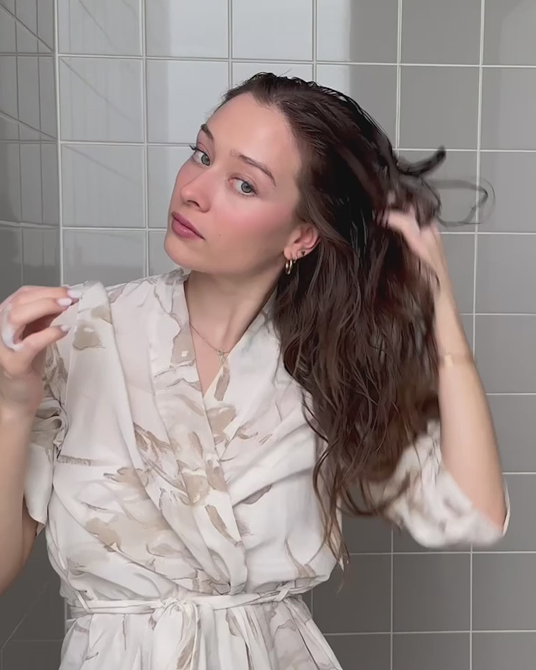 Frau arbeitet Volumen Mousse in feuchte Haare ein