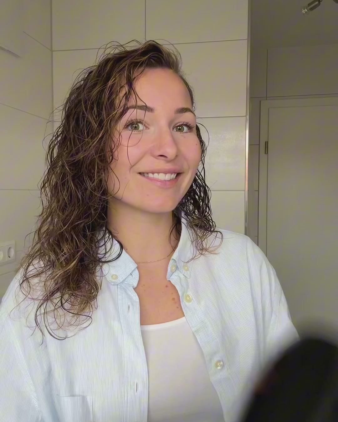 Frau mit Locken föhnt sich ihre Haare mit einem Diffuser