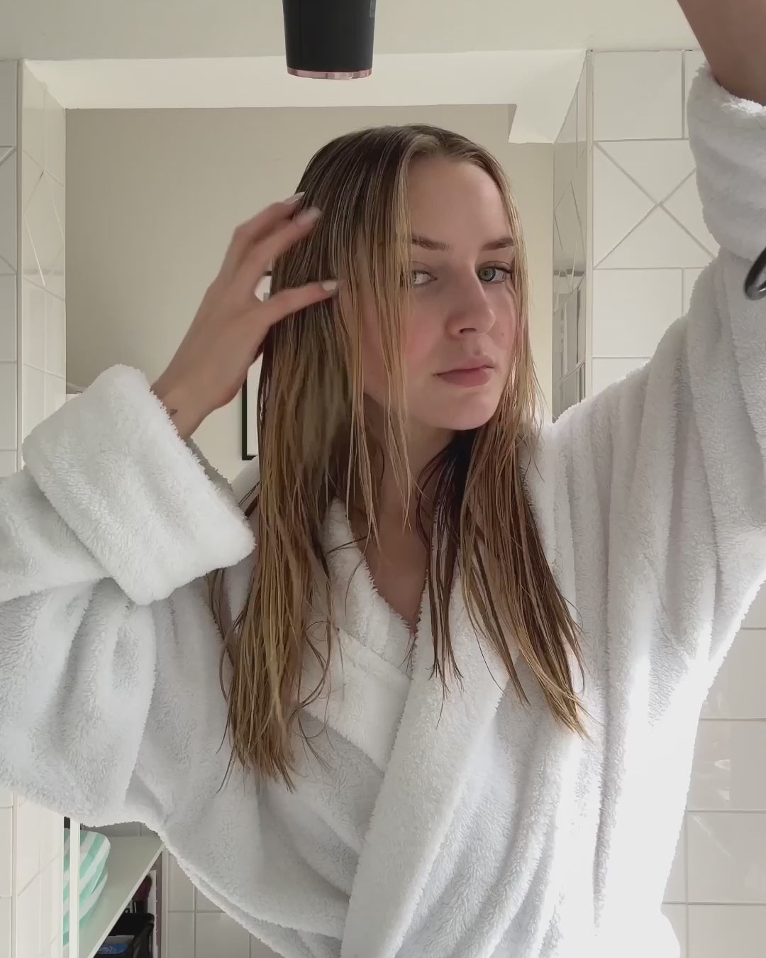 Frau föhnt ihre Haare