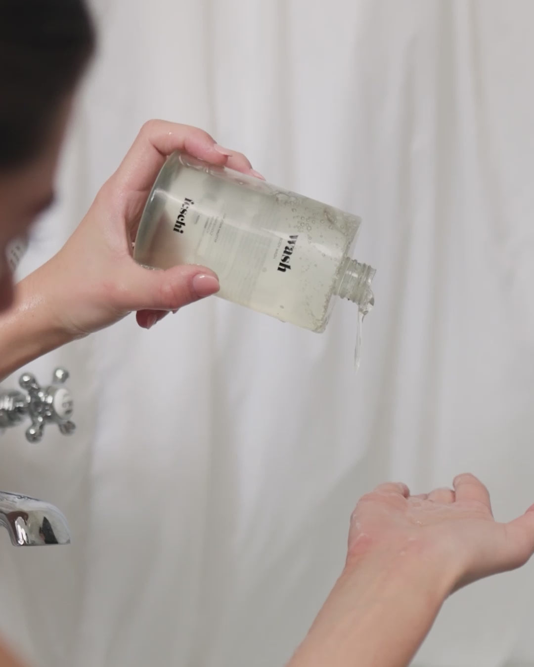 Frau gießt feschi Body Wash in Hände