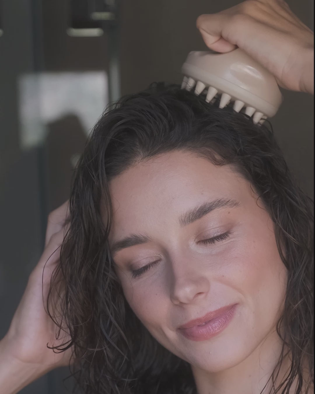 Frau massiert sich den Kopf mit einer scalp brush von feschi